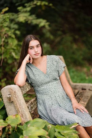 Portrait in a floral garden featuring a gray dress and natural garden backdrop.