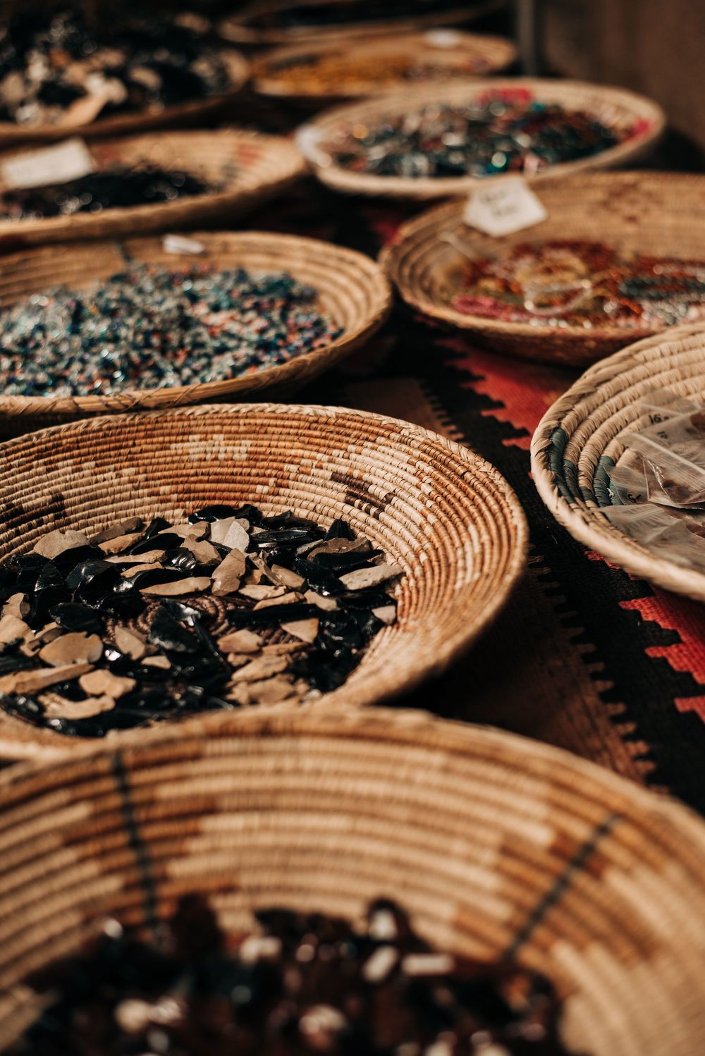 Traditional woven baskets filled with various spices and herbs displayed at a market.