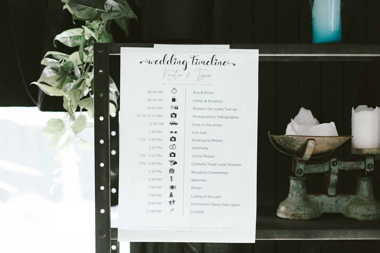 Wedding timeline schedule displayed next to decorative greenery and decor items.