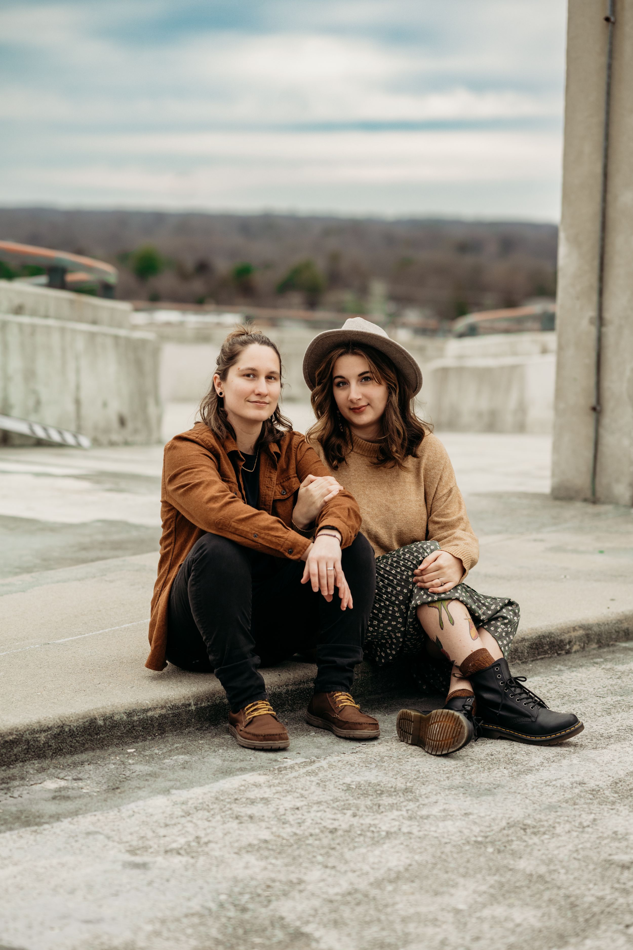 two people sitting on concrete parking deck