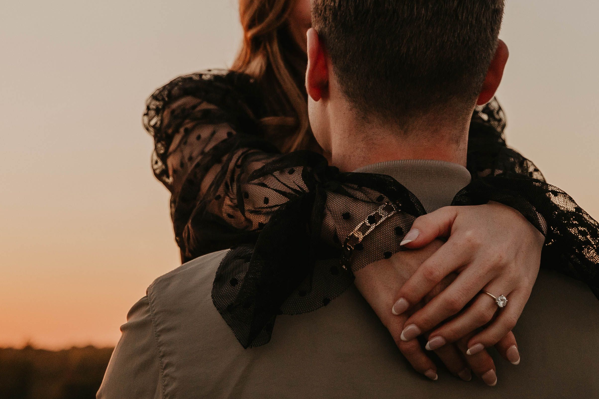 Close-up of couples hands showing engagement ring.