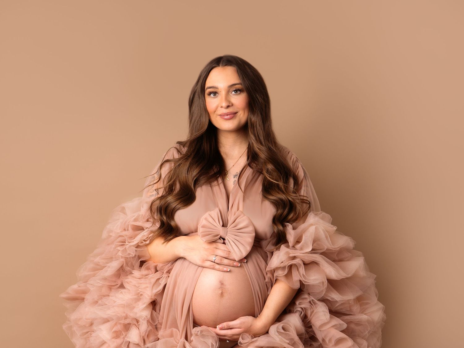beautiful pregnant mother with long hair in luxury pink maternity gown professional newborn photographer in Doncaster.