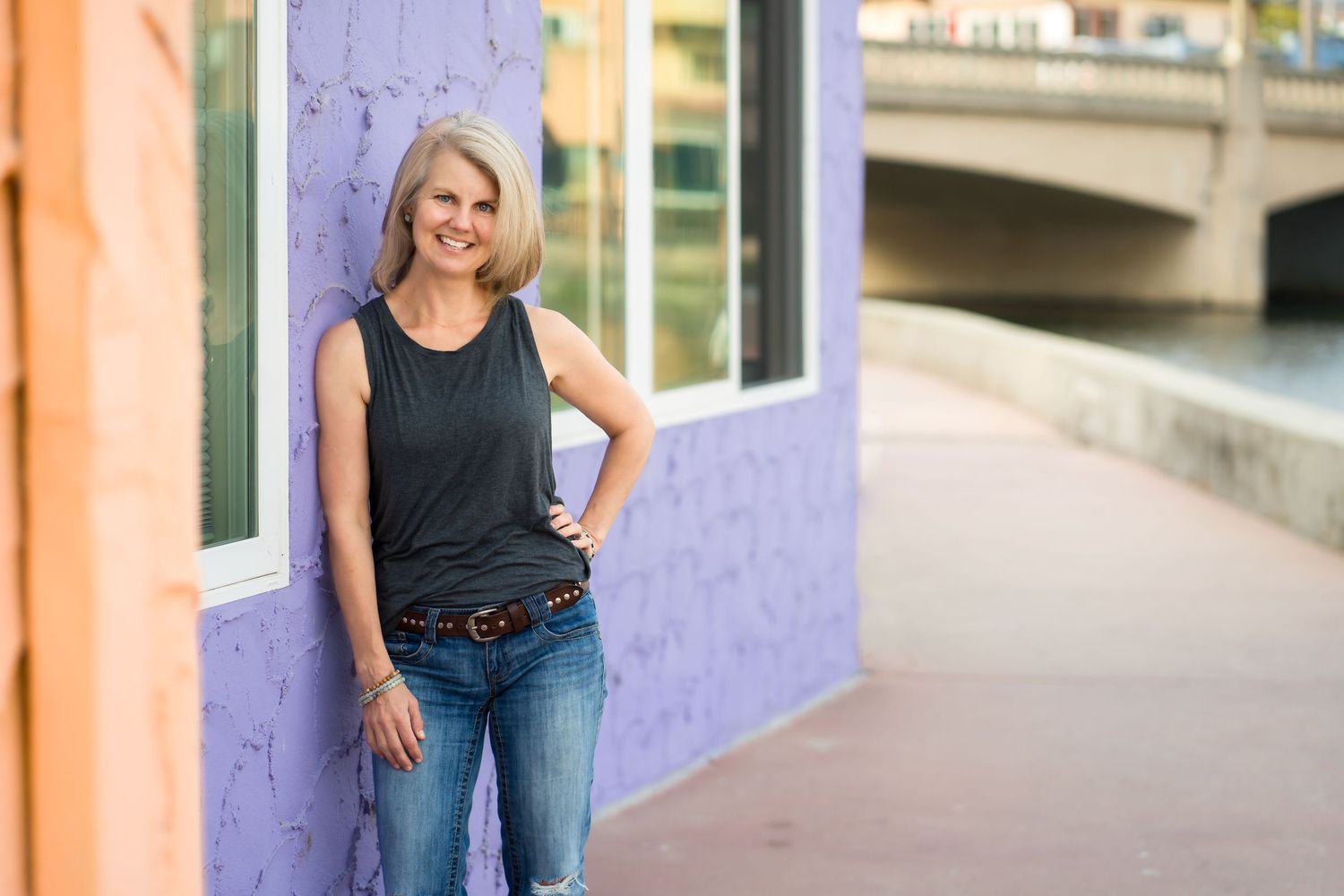 Woman smiling and leaning on a wall during personal branding session
