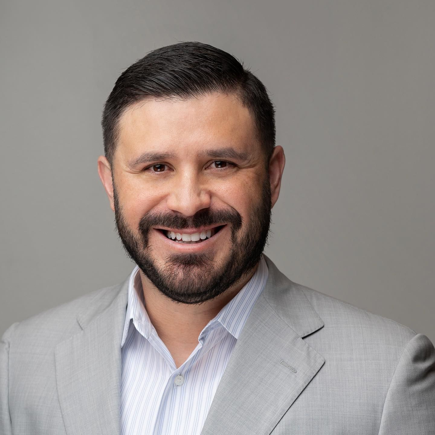 Orlando headshot photographer Ray Alvarez — male business owner headshot in light gray suit with clean background