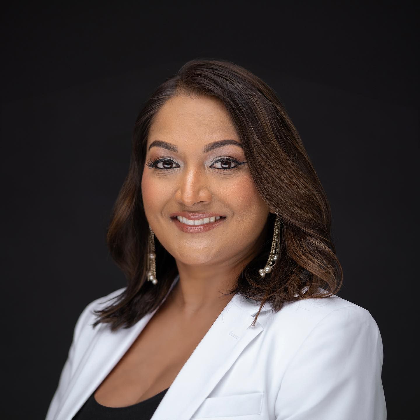 Orlando headshot photographer Ray Alvarez — insurance agent headshot in white blazer with dramatic dark background