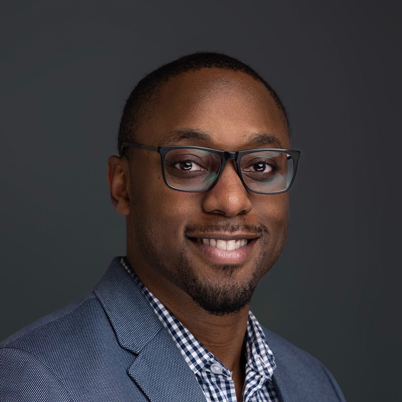 Orlando headshot photographer Ray Alvarez — business consultant headshot in gray blazer with dark studio background