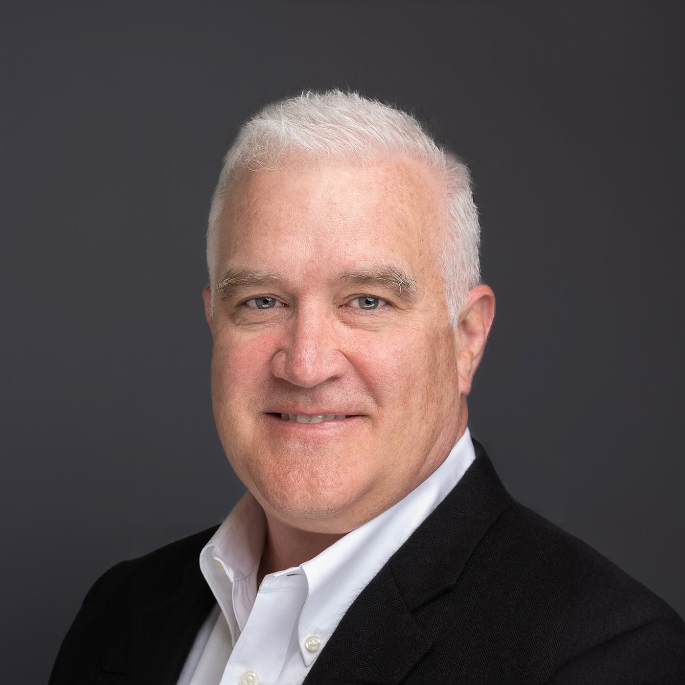 Orlando headshot photographer Ray Alvarez — CFO headshot in classic black blazer with dark professional background
