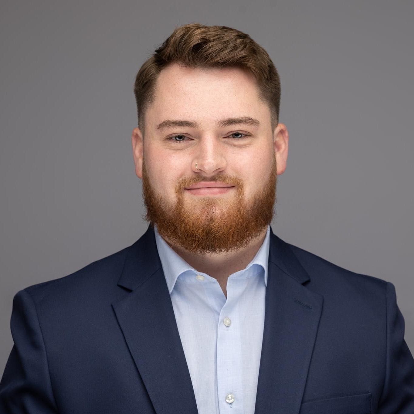 Orlando headshot photographer Ray Alvarez — law school graduate headshot in navy suit with clean gray studio background