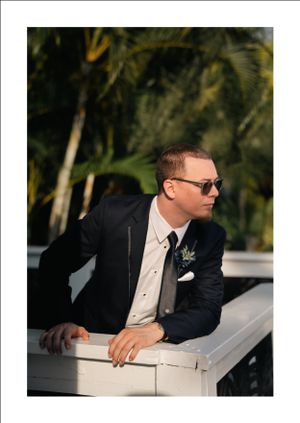 Groom strikes a pose for photographer, during get ready photos, outdoors, prior to the wedding ceremony.