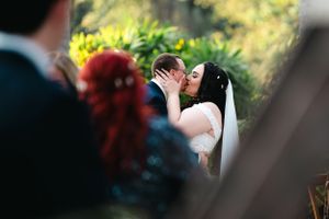 Bride and groom kissing during the wedding ceremony in beautiful outdoor venue