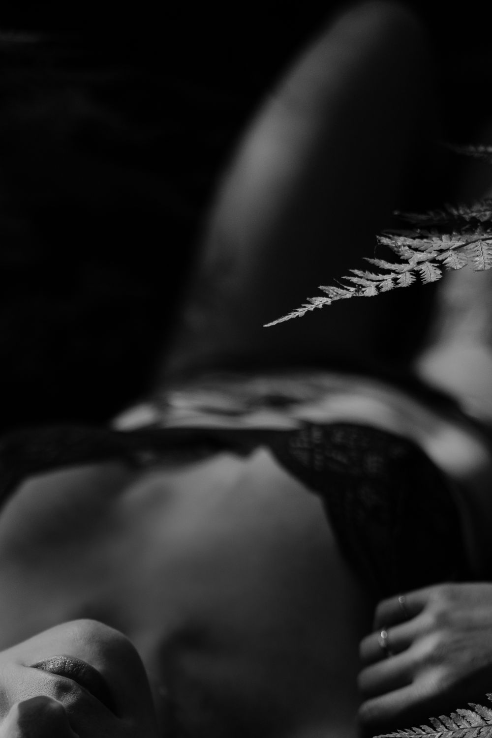 Artistic black and white intimate portrait with dramatic shadows and lace details.