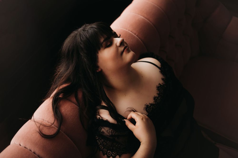 Intimate boudoir portrait against dark backdrop showcasing sensual lace lingerie styling.