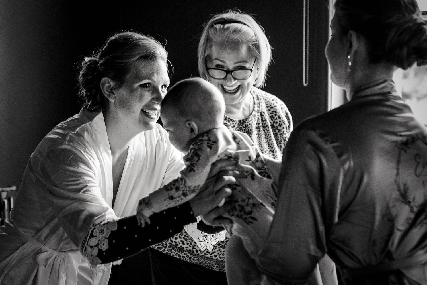Candid black and white photos of wedding day preparation moments.