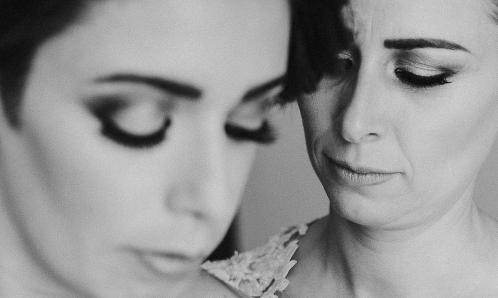 Close-up black and white portrait showcasing glamorous wedding makeup and lace details.
