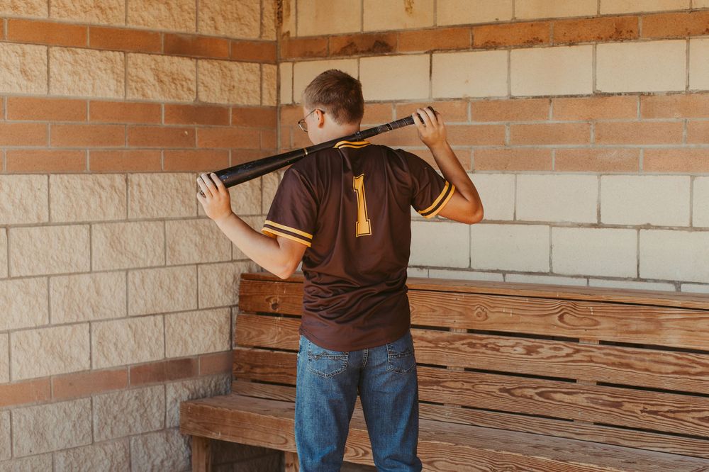Person standing against white brick wall near wooden pallets.