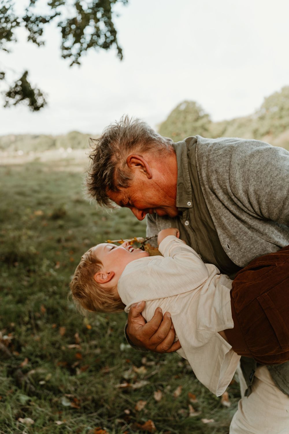 A playful moment captured between two people on a grassy hillside.