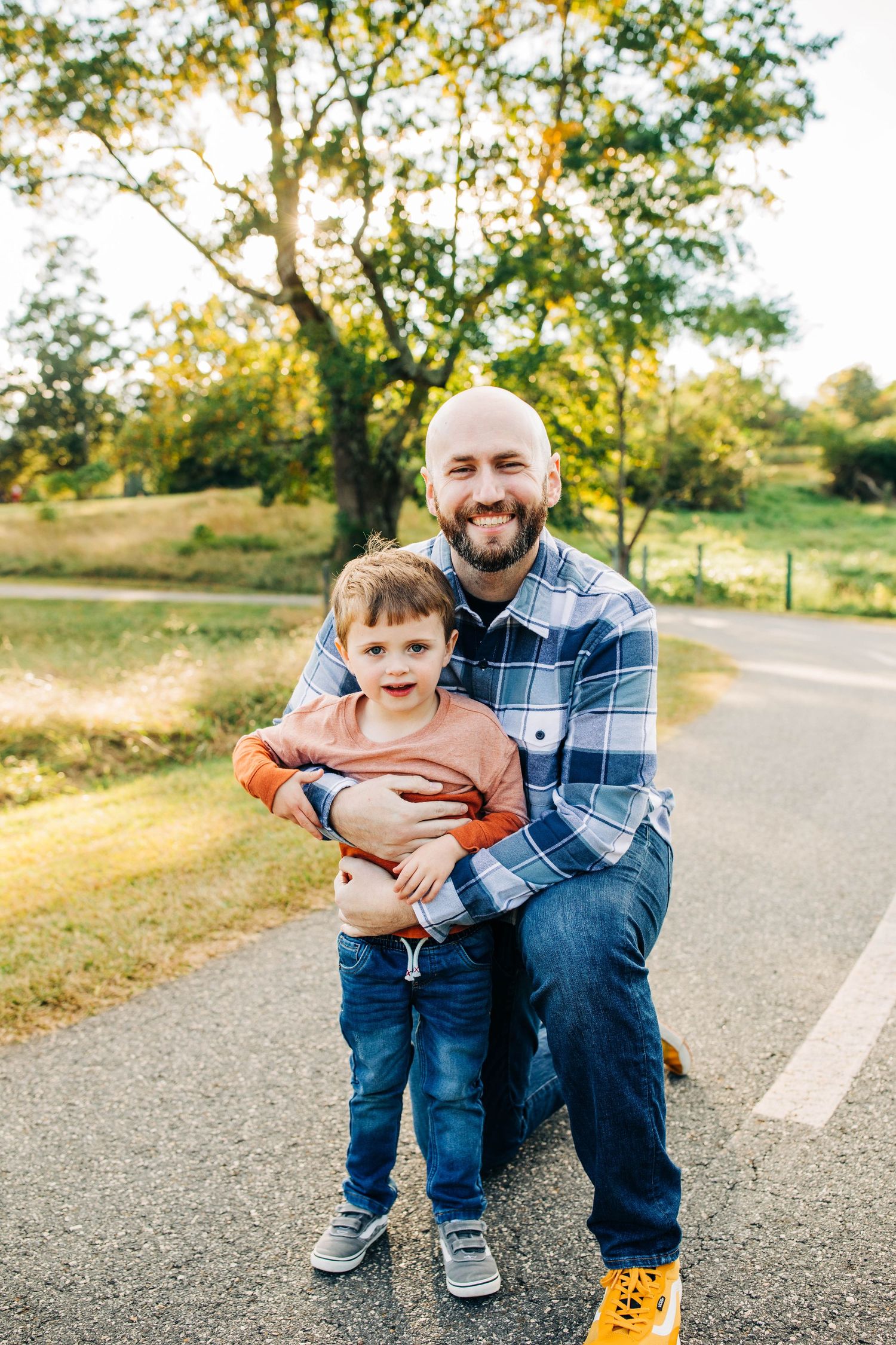 Father and young child posing together on path during golden hour sunset.