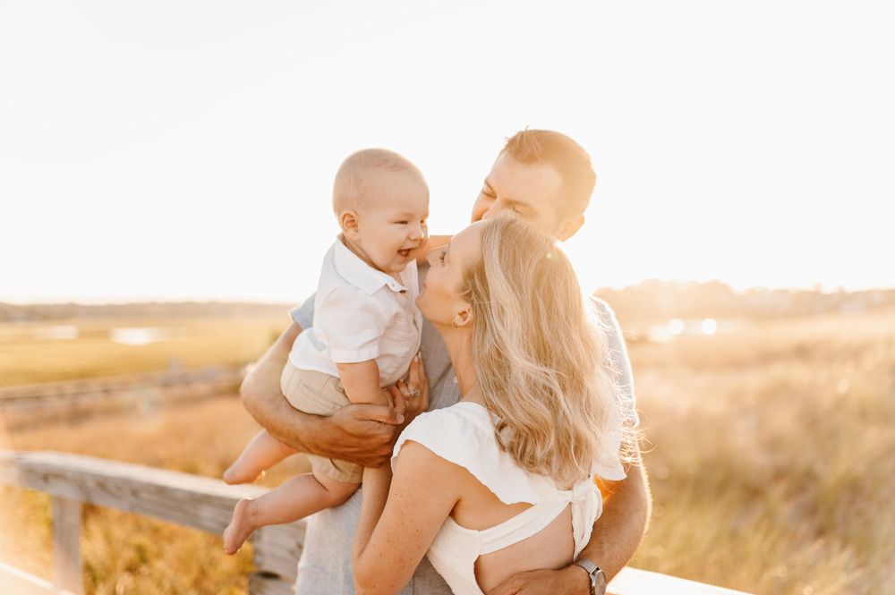 A family shares joyful moments together during a golden sunset photoshoot at the beach.