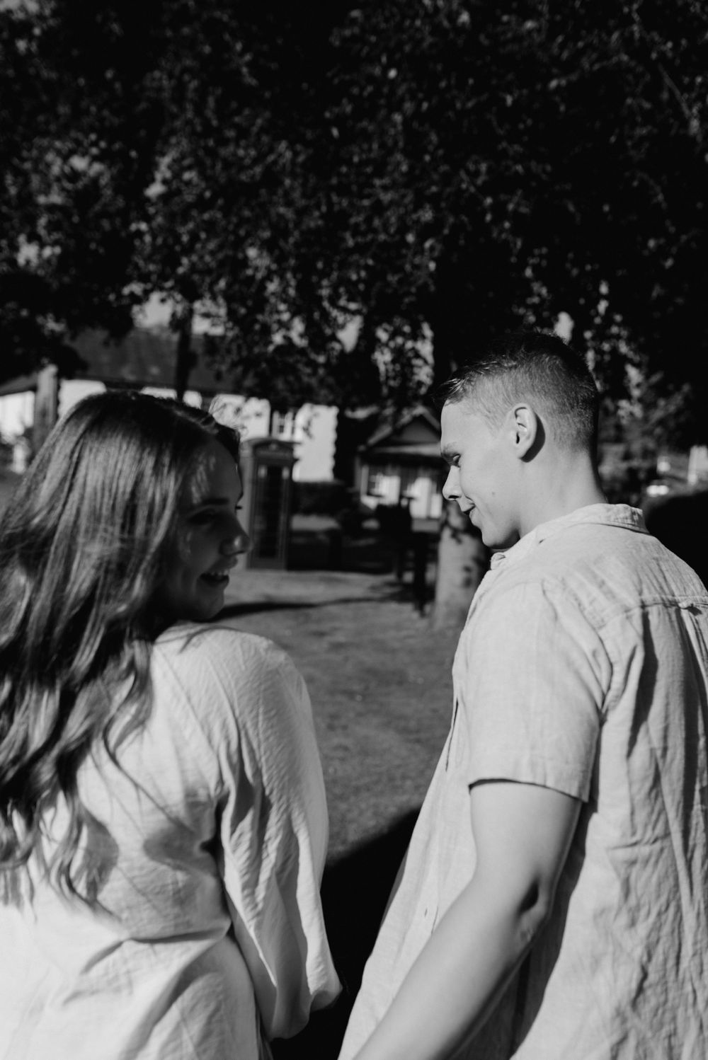 A black and white image of two people having a conversation outdoors.