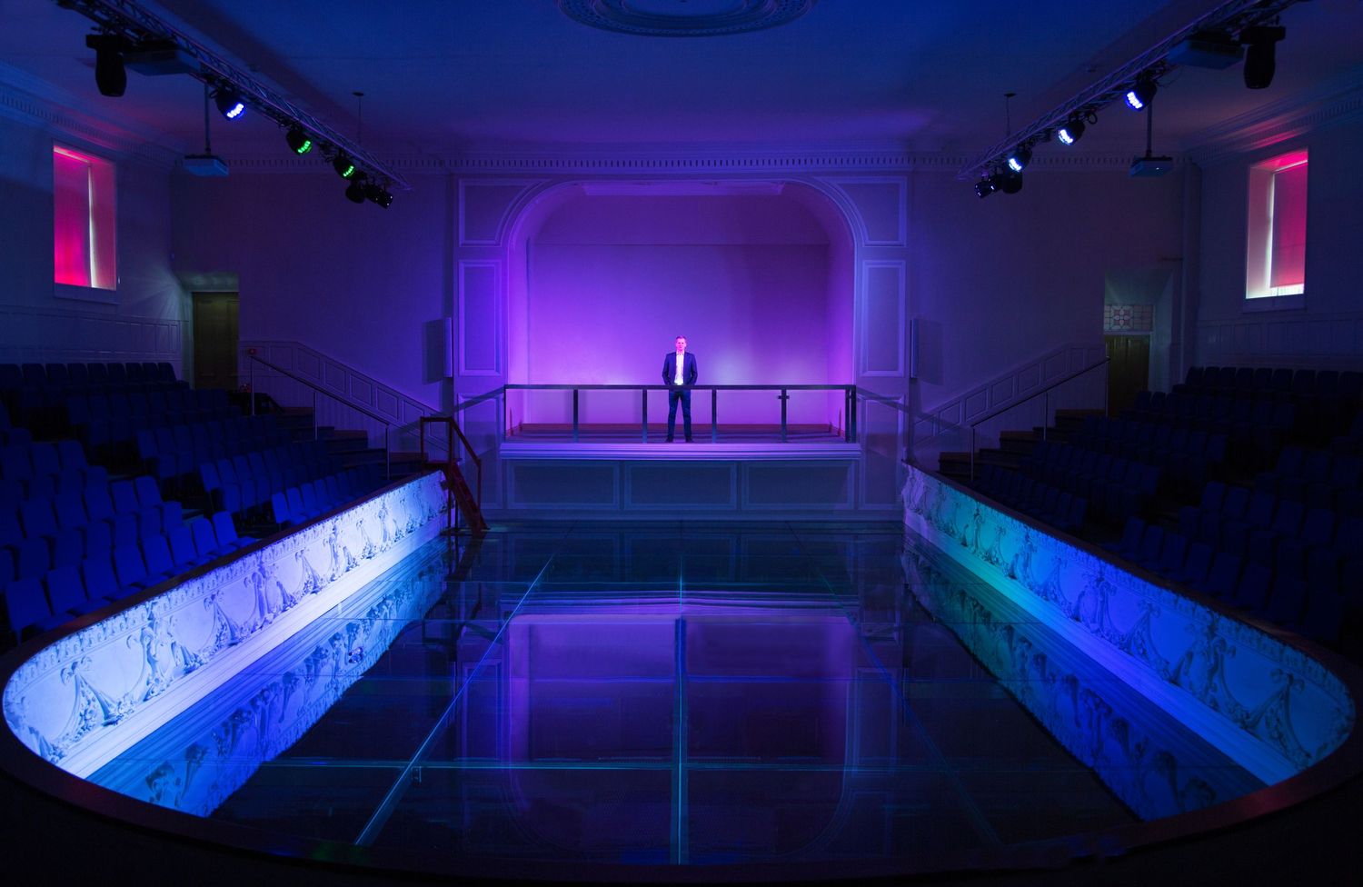 Workplace Photograph Shot By Gary Brown of a business director on a stage with LED lighting effects