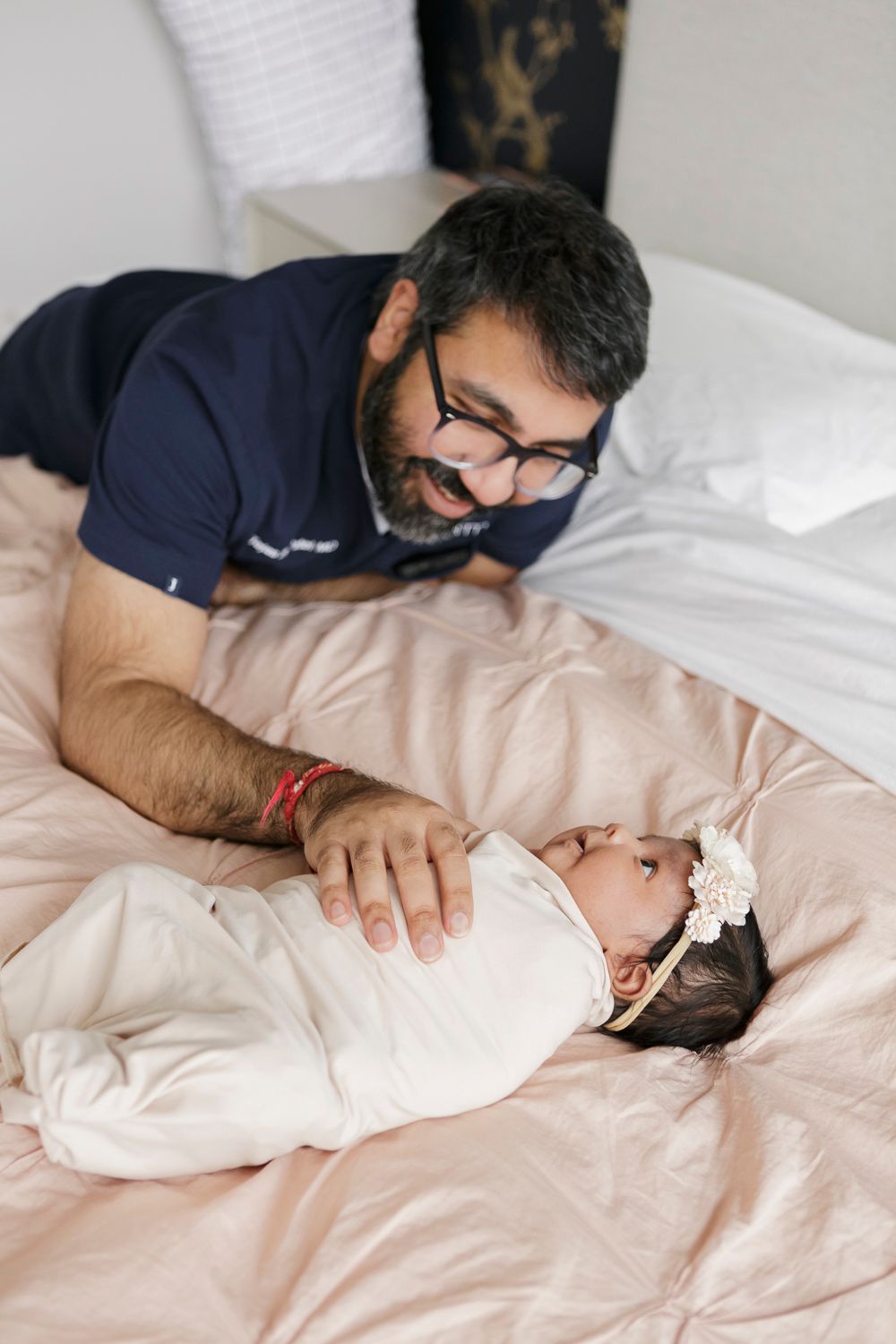 Dad comforting his newborn baby during a cozy moment, photographed by Paula Ortiz in NYC