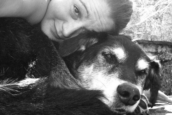 BW image close up on a young woman with her head on her dog.