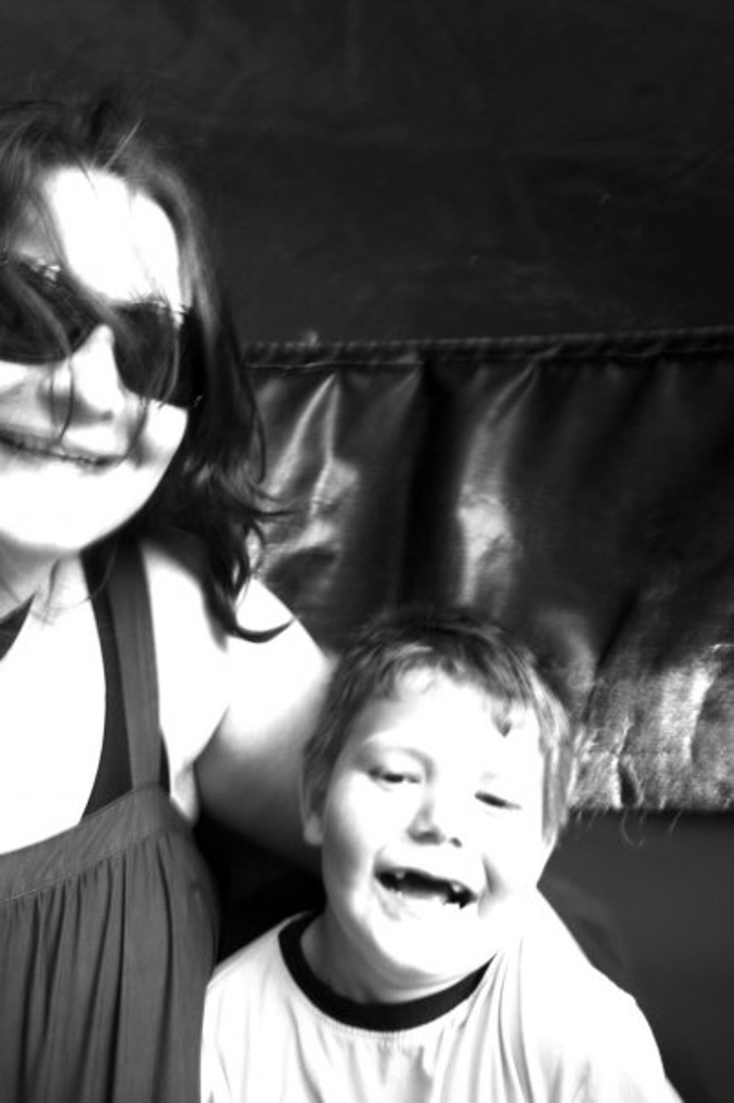 Blurred bw photo of a young woman and a young boy as they twirl in a tea cup ride at the fair.