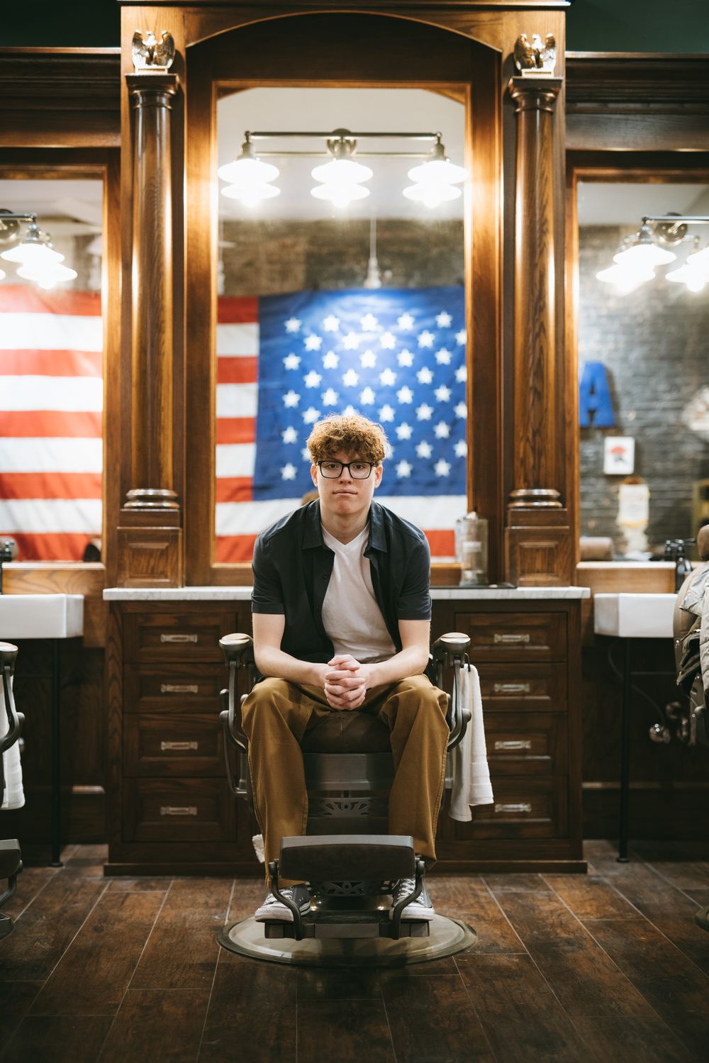 Vintage barber shop interior with American flags and classic chair showcases traditional barbering aesthetic.