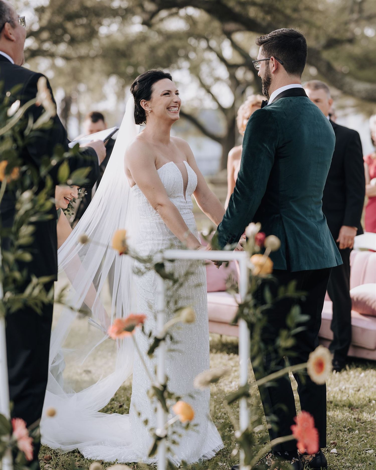 Happy couple sharing emotional moment during outdoor wedding ceremony with spring flowers.