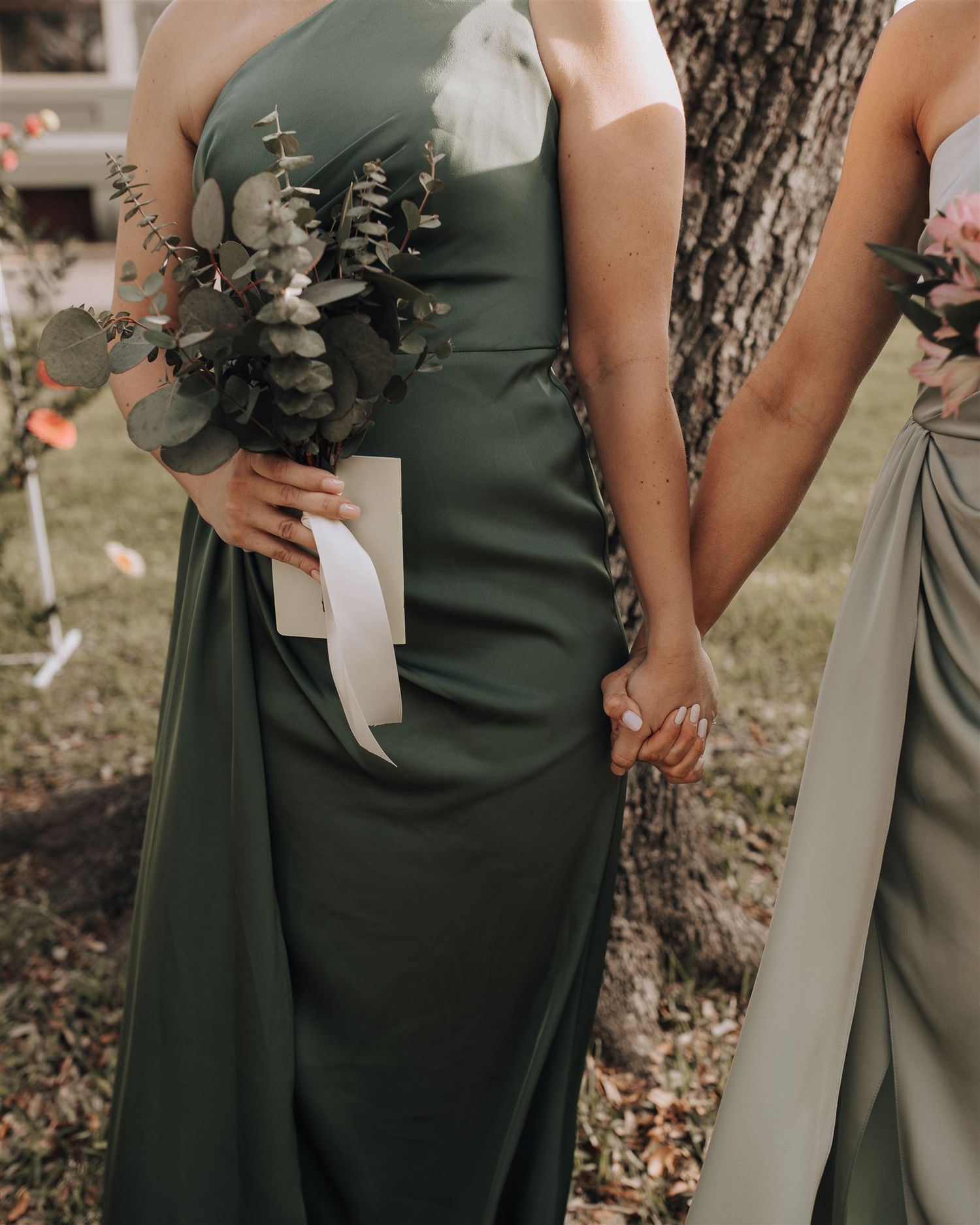 Elegant forest green bridesmaid dress with a gathered bouquet featuring eucalyptus leaves and white flowers.