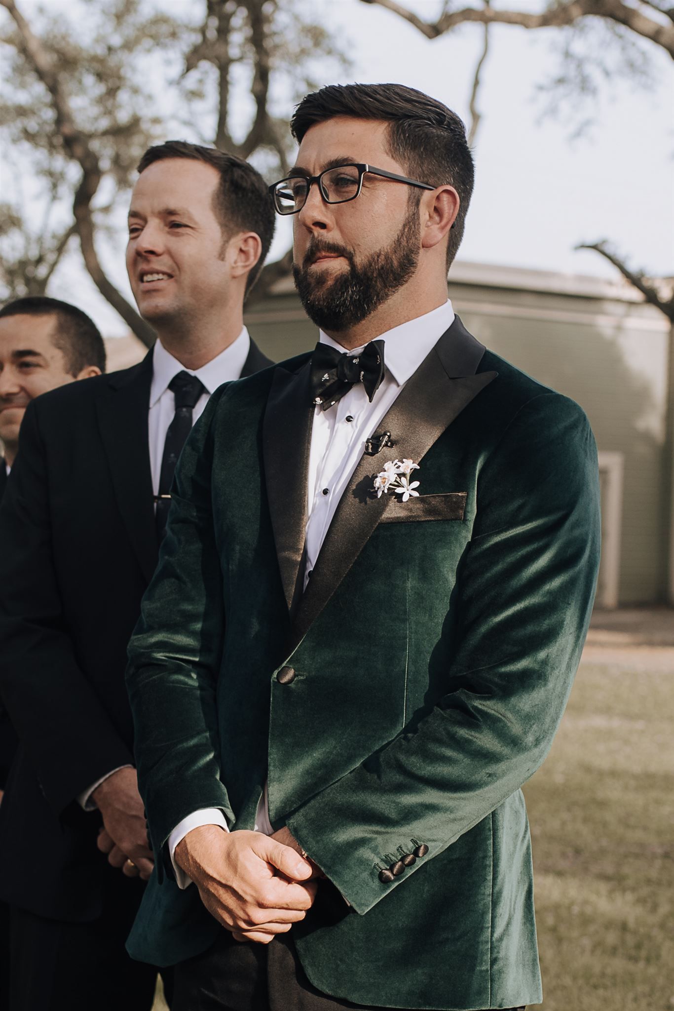 Wedding party member wearing a luxurious emerald velvet tuxedo jacket with black bow tie.
