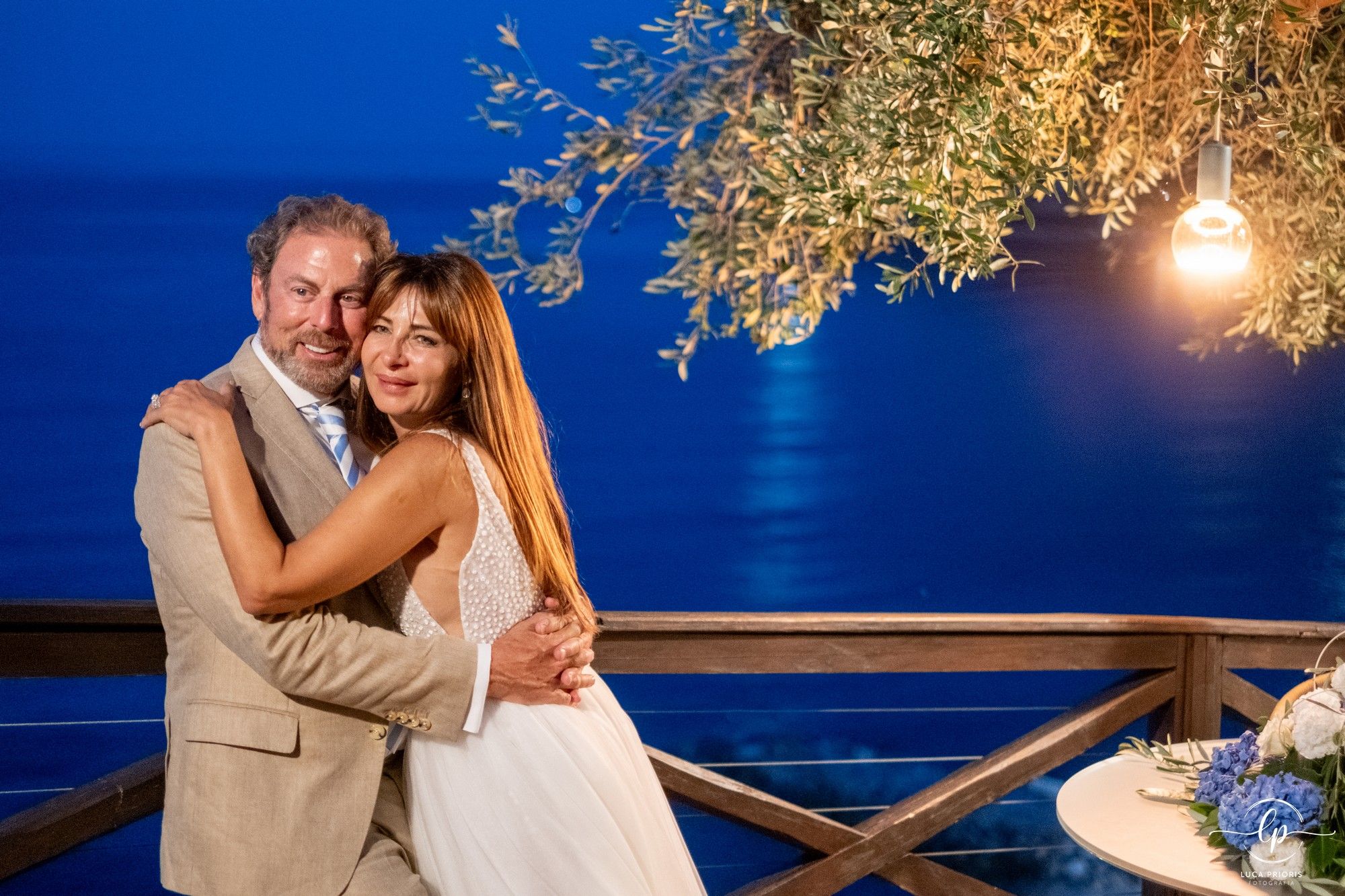 sposi al tramonto con il mare sullo sfondo