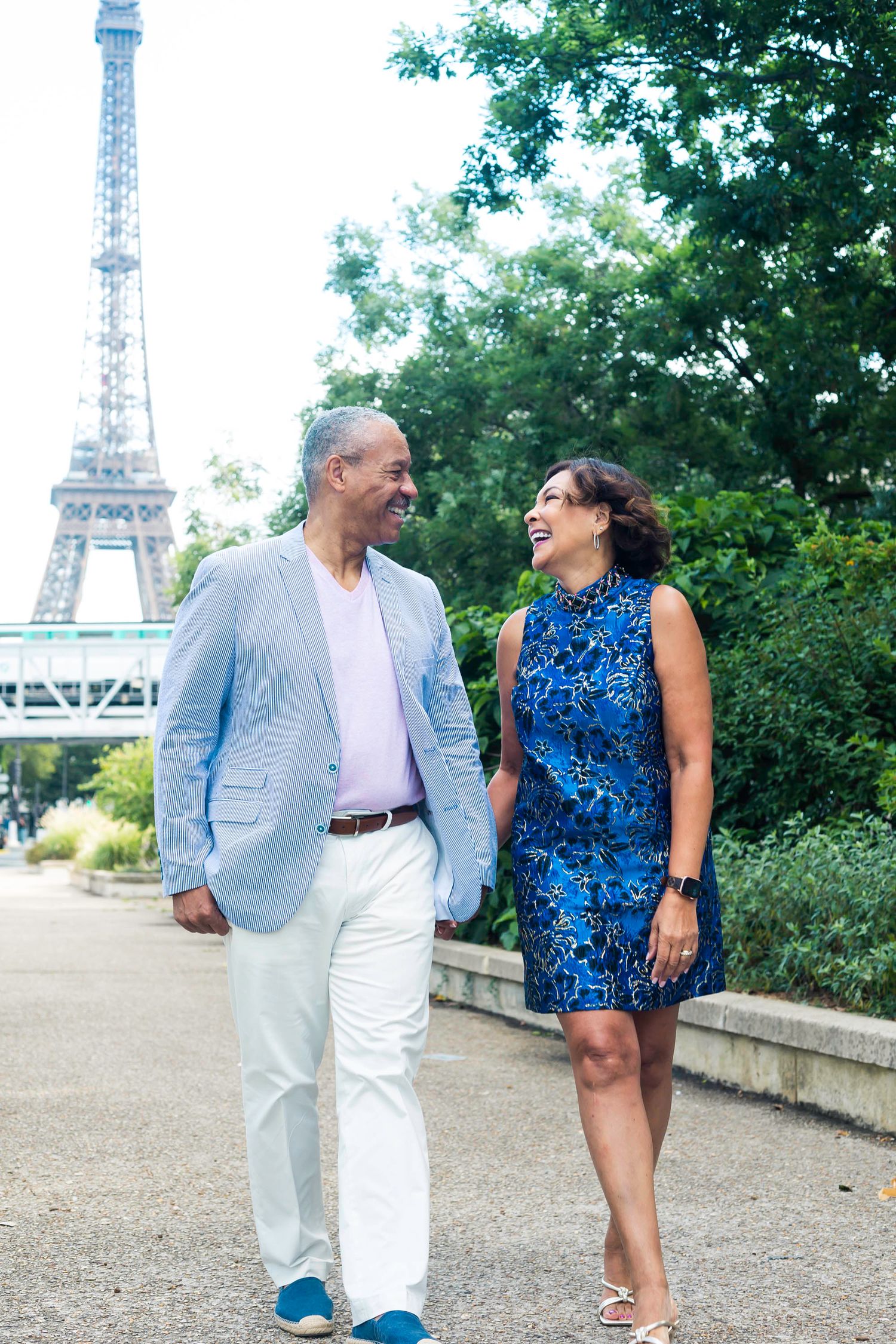 Black couple walking and laughing in front of Eiffel Tower