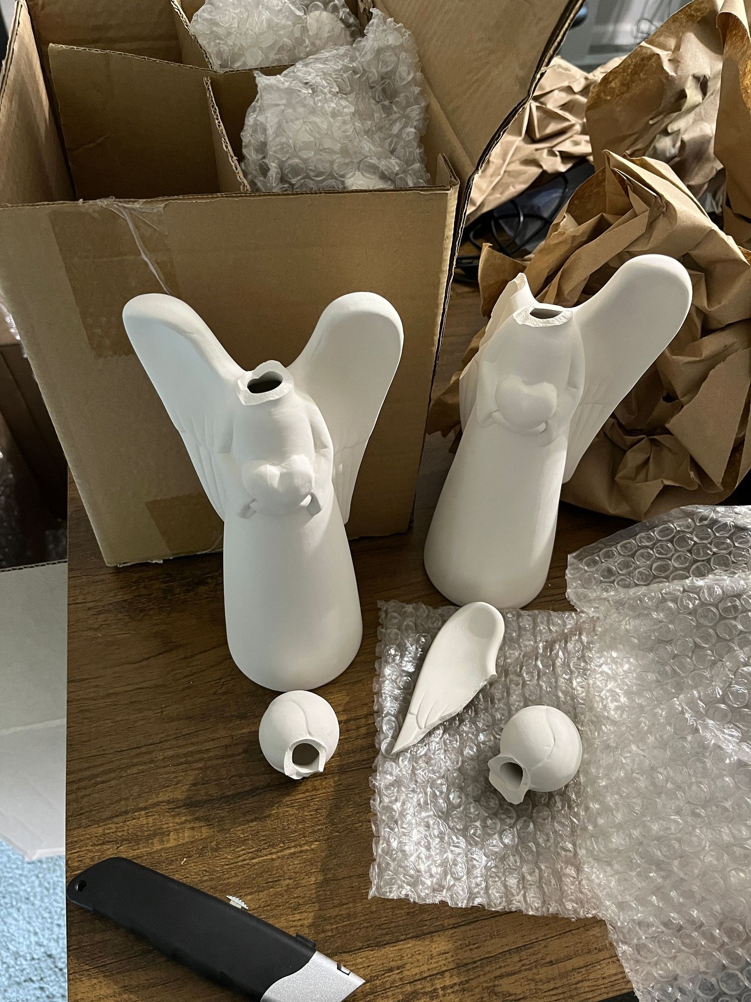Photo of two ceramic angels that arrived broken from shipping.