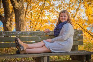 fall portrait of girl sitting on bench