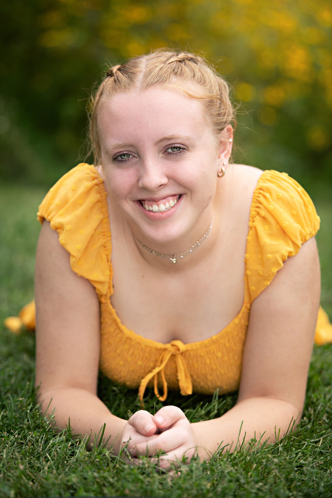 Summer portrait in a yellow dress amid wildflowers with soft natural lighting.