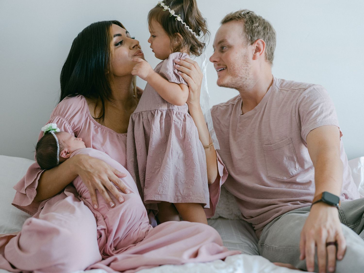 In Kaysville, Utah a newborn baby is with her family on the bed.