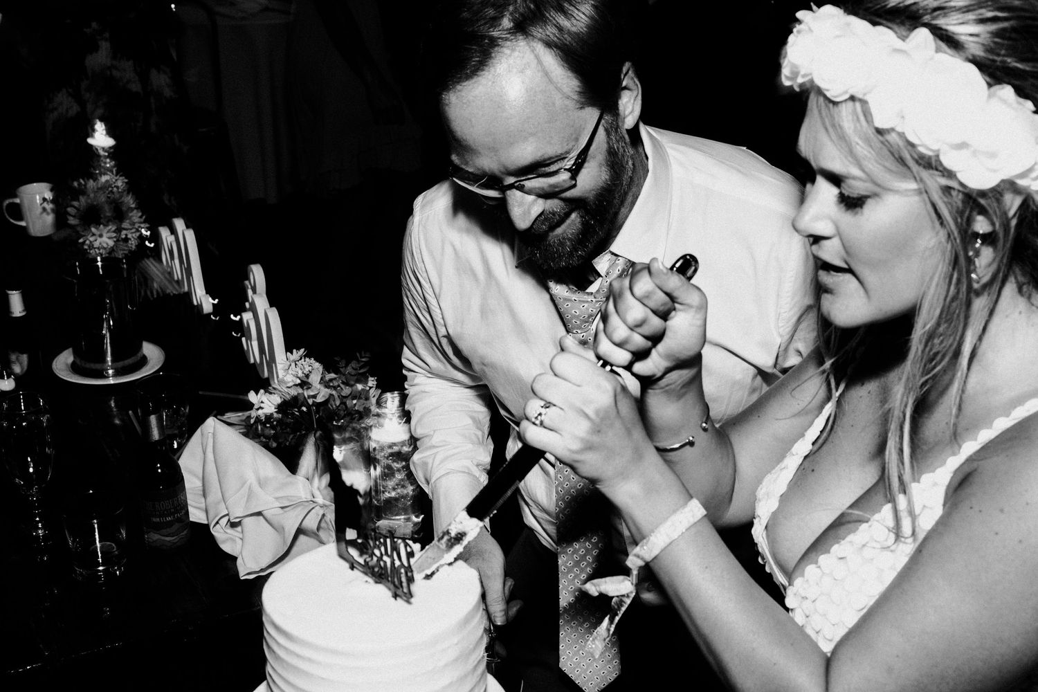 Black and white candid party moment with people enjoying drinks at night.