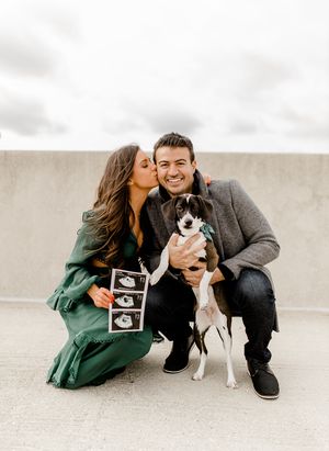 Couple poses with their dog and ultrasound photos during pregnancy announcement photoshoot.