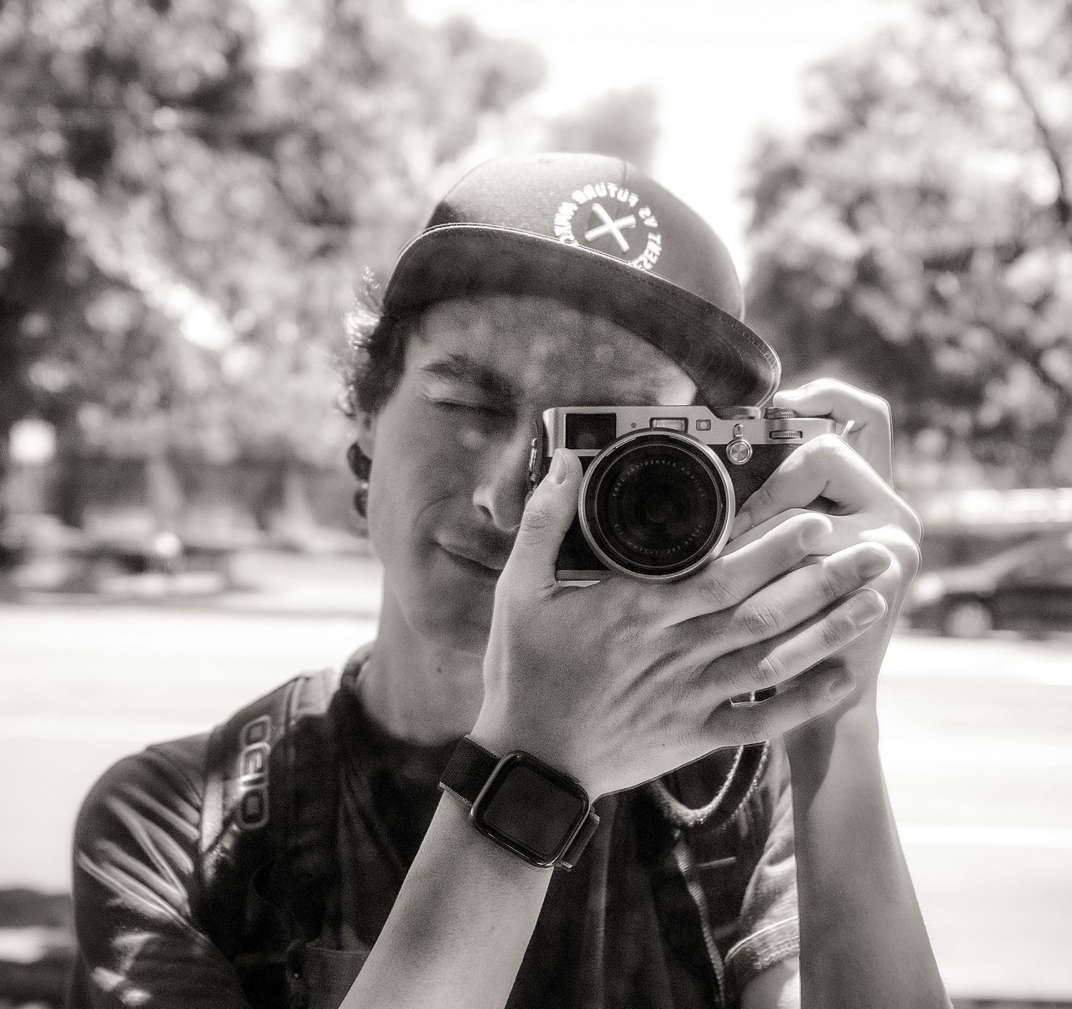Black and white close-up of a person taking a photo with a professional camera.