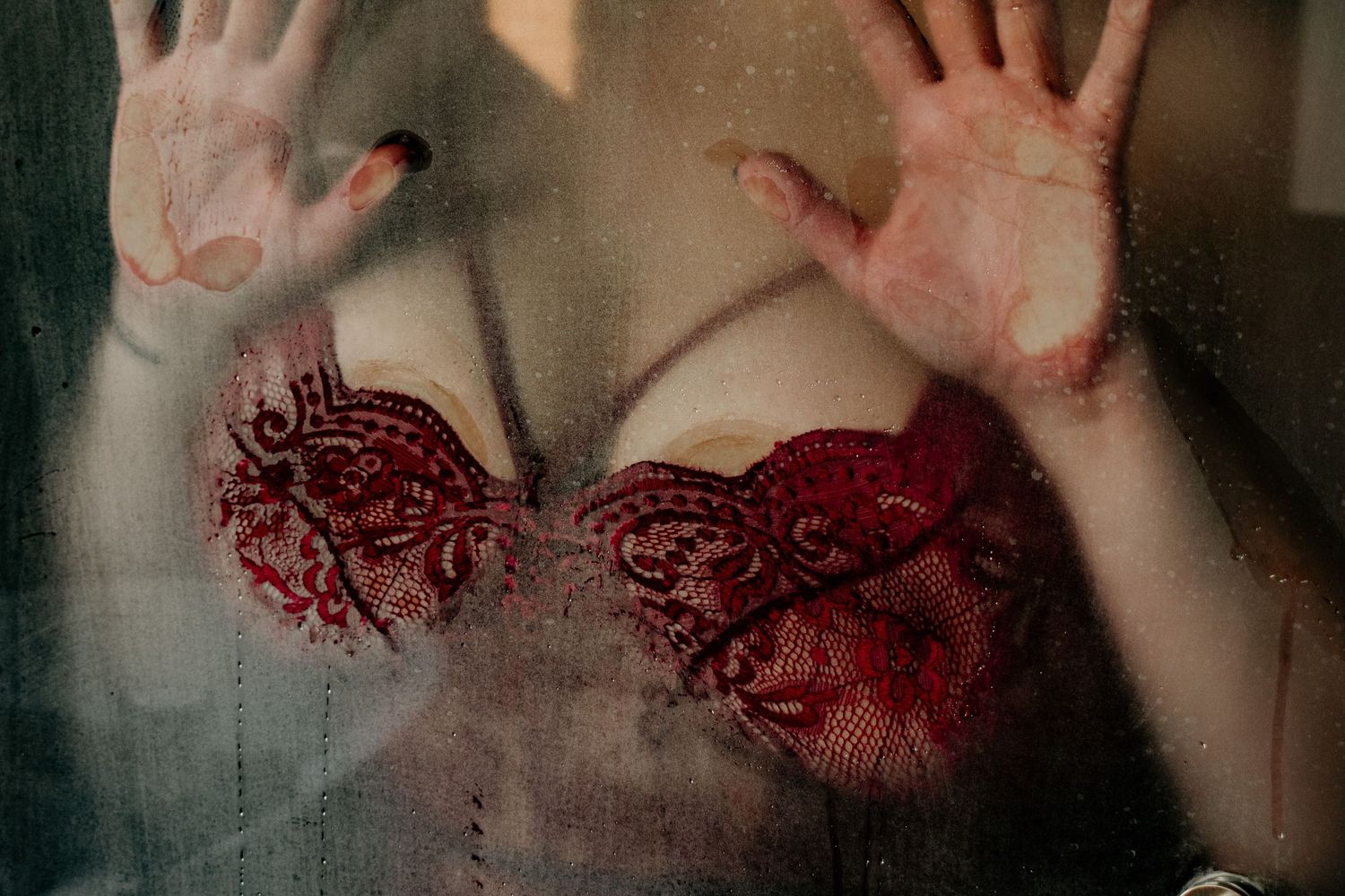 woman pressing her chest on steamy shower door with lingerie on