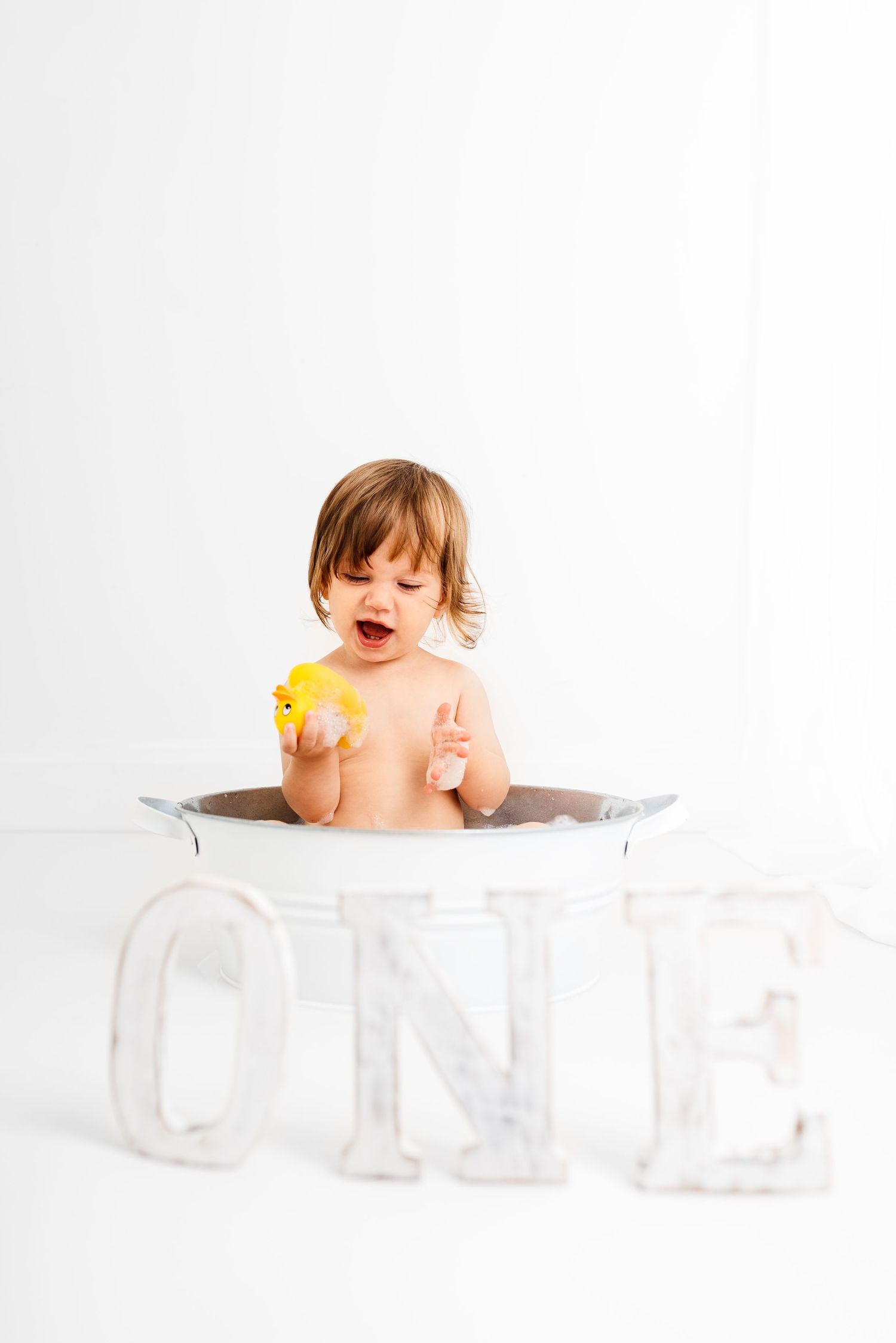 baby all white splash first birthday photoshoot with yellow duck Hereford