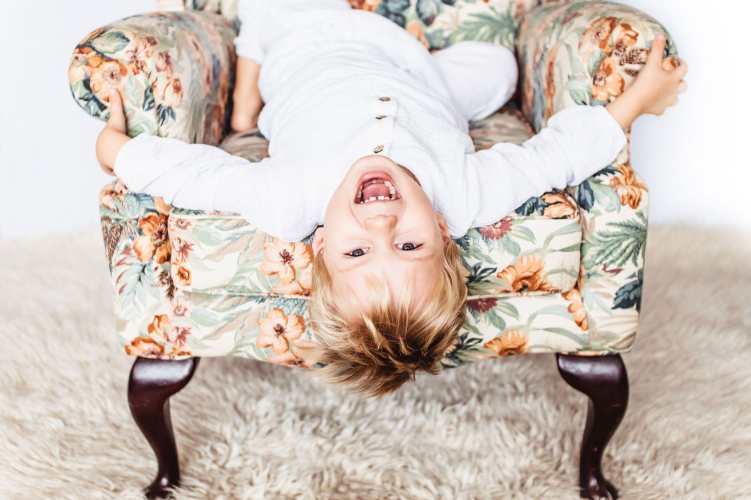 a boy playing on a chair baby photo all white background