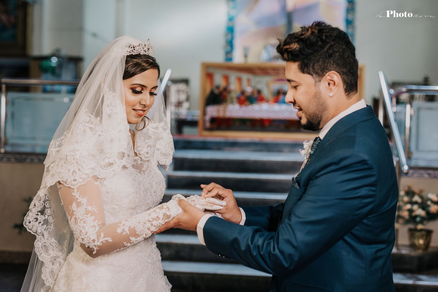 Wedding ceremony scene with couple in traditional attire exchanging rings at the altar.
