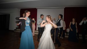 Wedding guests dancing and celebrating on the dance floor.