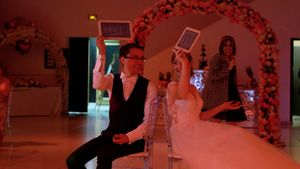 Wedding reception venue decorated with red lighting and floral arches.