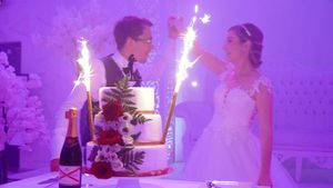 Wedding couple dancing under purple lighting effects during their first dance at an elegant reception.