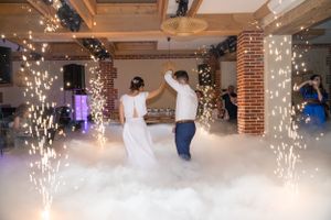 Wedding couple's first dance with sparklers and fog effects creating a magical atmosphere.