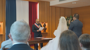 Wide angle view of wedding ceremony setup with red and blue drapery and wooden paneling.