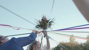 Colorful streamers and decorations against a bright blue sky at an outdoor celebration.